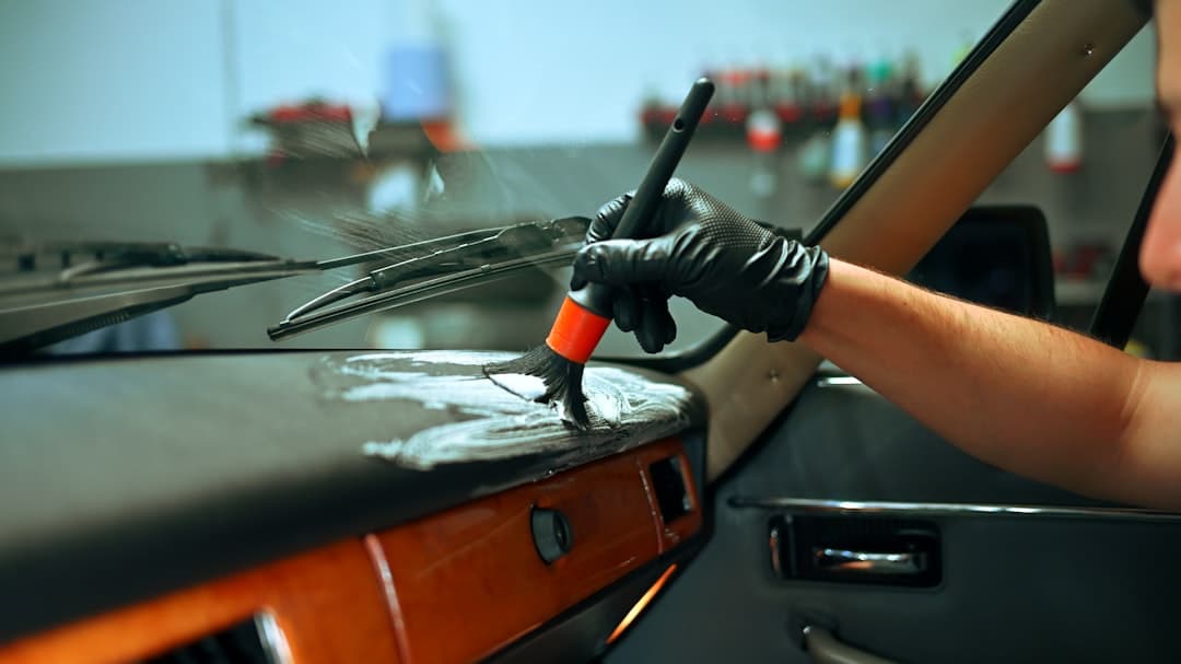 Detailer cleaning the dashboard of a classic car